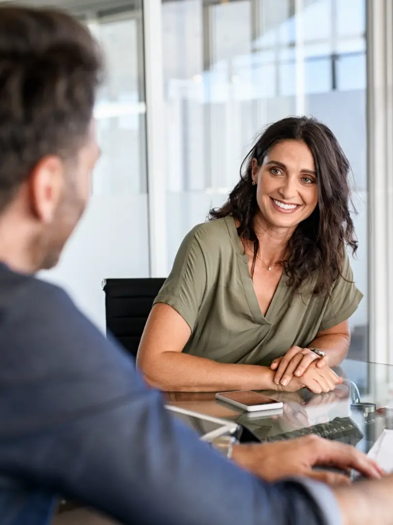 A woman sitting at a table with another man.